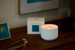 Candle burning on a wooden surface with a box and decorative items in the background