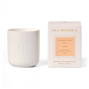 White candle with embossed design next to its packaging on a white background