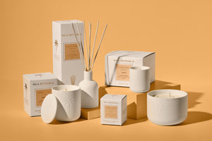 Set of candles and diffusers with boxes on a beige background