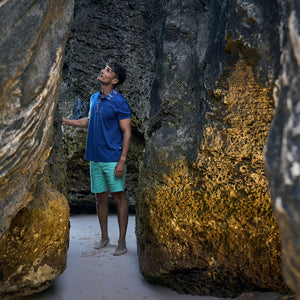 Person standing between large rocks on a beach