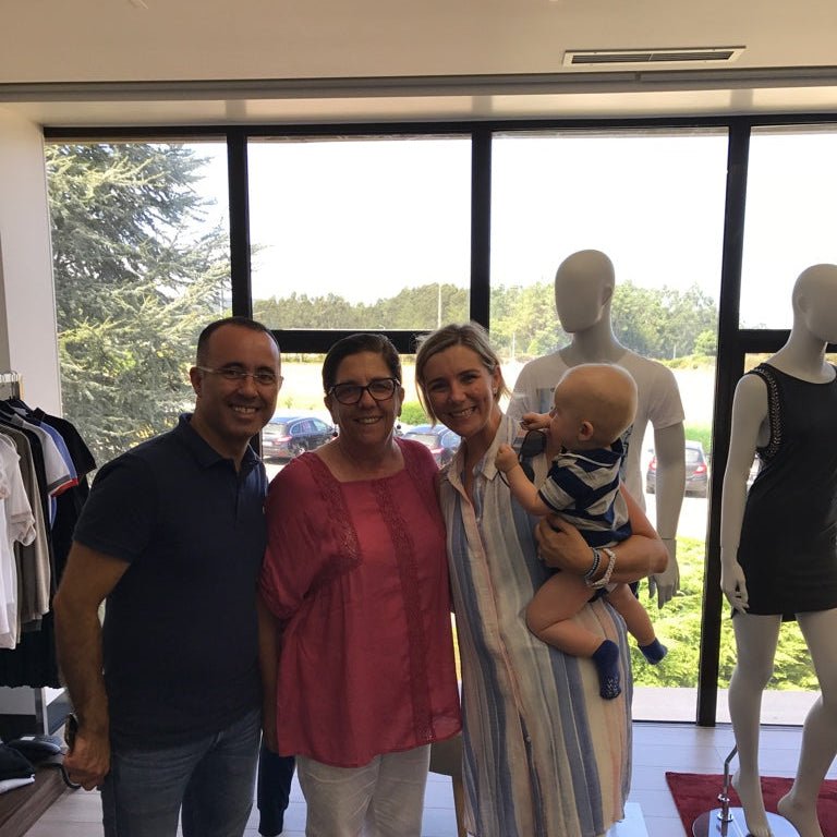 Family of four with a baby in a clothing store with mannequins in the background