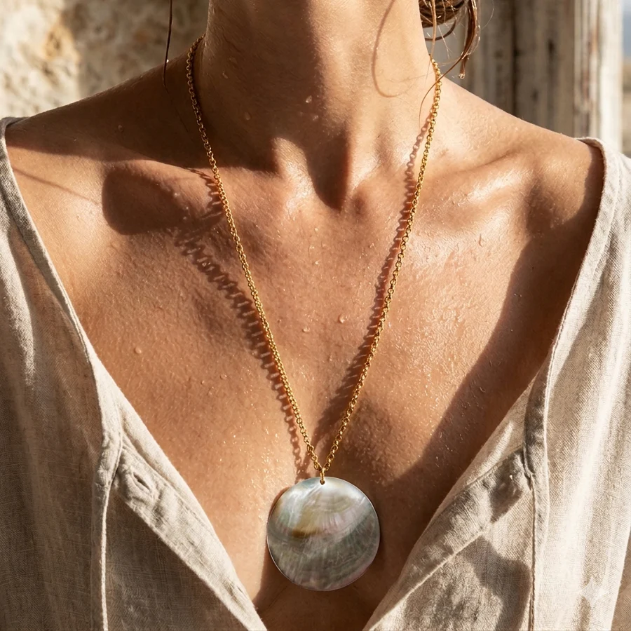 Necklace with a large round pendant worn by a person against a neutral background
