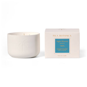White candle and its packaging labeled 'Isla Botanica Night Bloom' on a white background