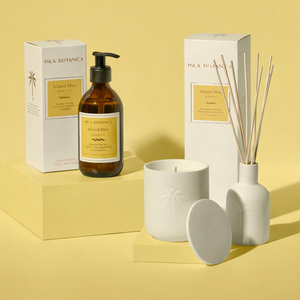 Collection of home fragrance products including a candle, diffuser, and bottle on a yellow background.