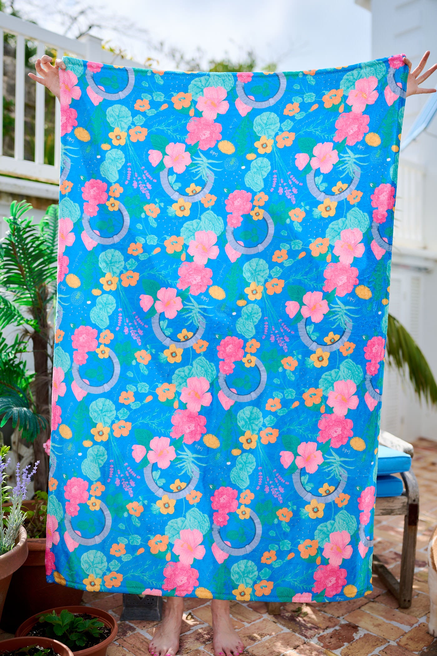 Child wrapped in a colorful towel with floral patterns outdoors