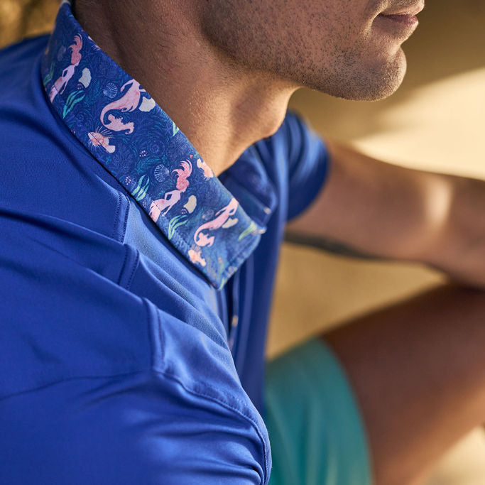 Close-up of a person wearing a blue shirt with a patterned collar.