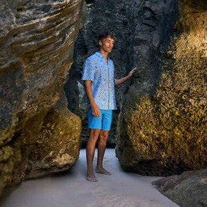 Man standing between two large rocks on a beach